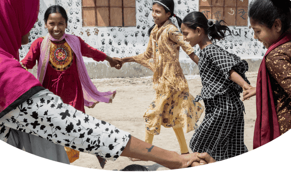 Barn håller varandra i händerna och dansar i en ring.